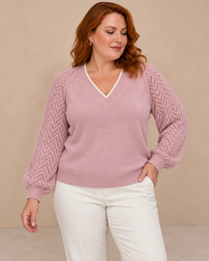 Modelo Cashia de cabello castaño en corte bob con jersey Saja rosa, talla M, medio plano superior.
