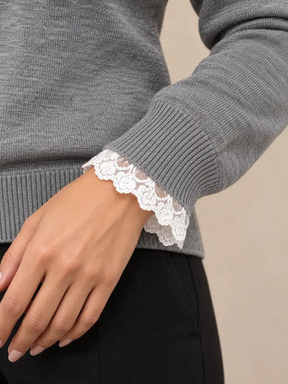 Jersey de mujer con encaje en cuello y puños de Cashia Sauco, detalle de encaje blanco en los puños.