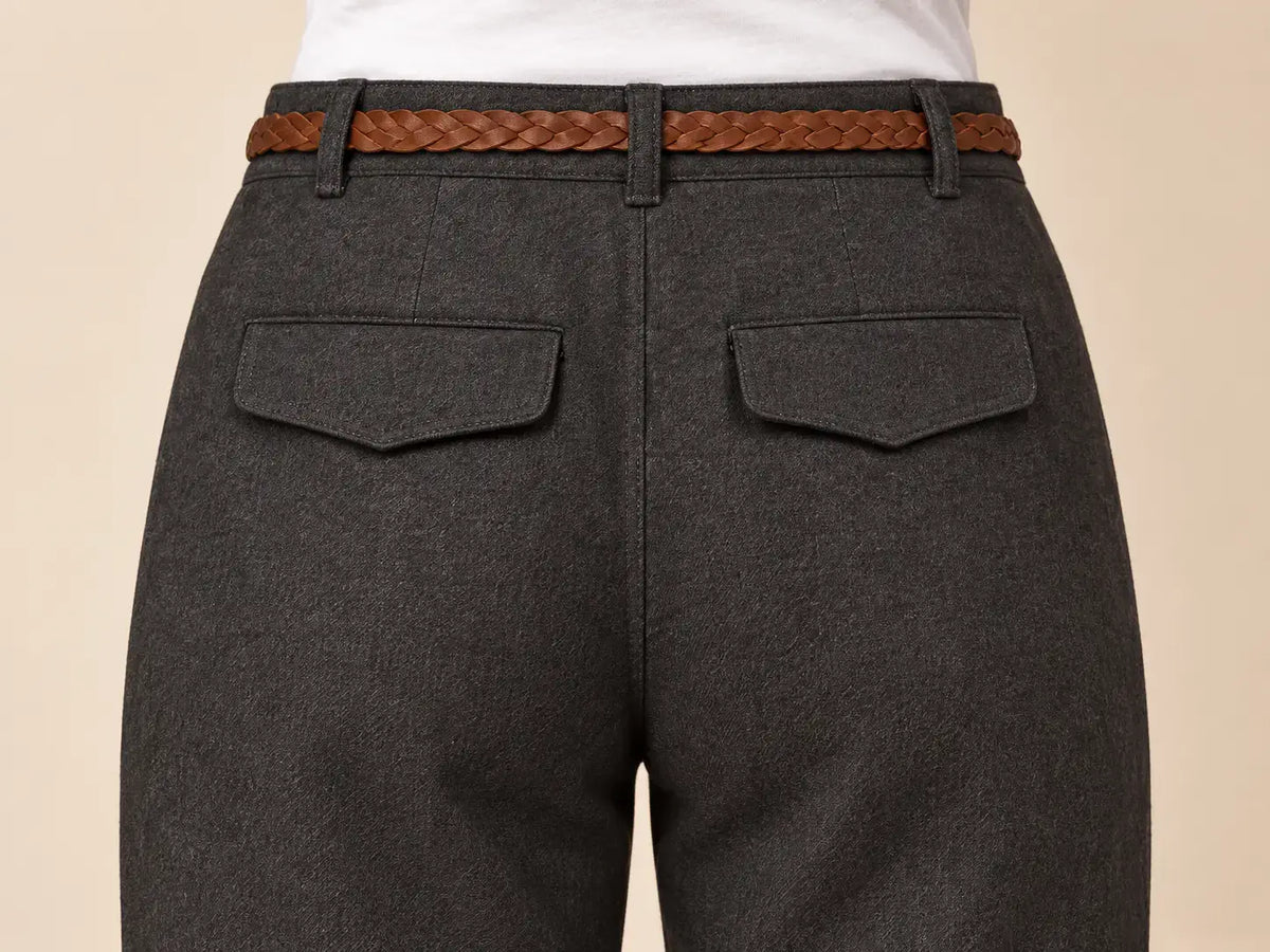 Vista posterior del pantalón de mujer recto con bajo vuelto, detalle del cinturón trenzado y bolsillos.