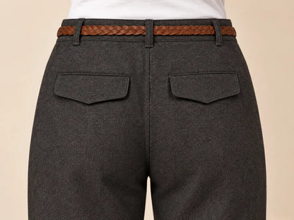 Vista posterior del pantalón de mujer recto con bajo vuelto, detalle del cinturón trenzado y bolsillos.