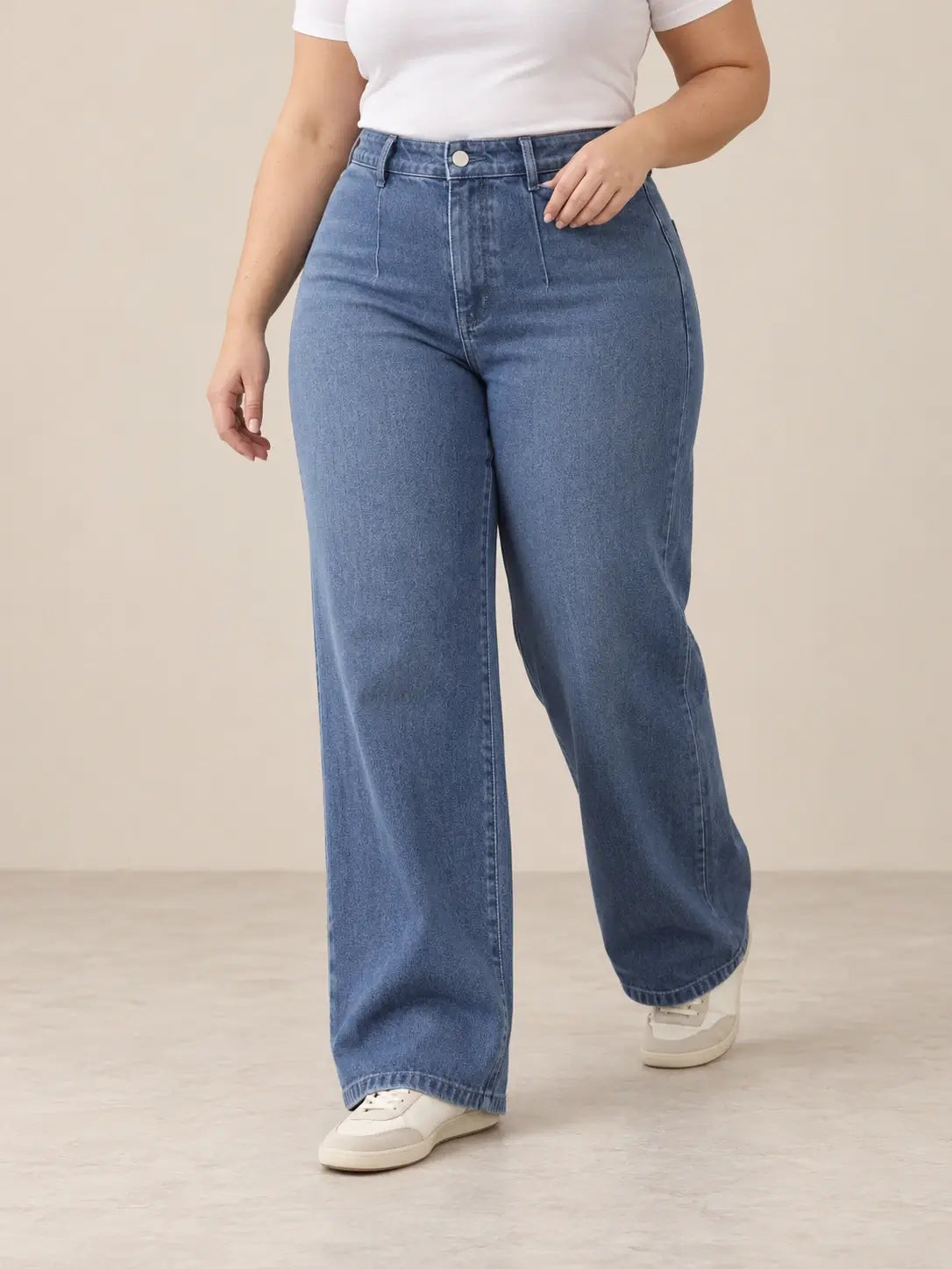 Pantalón Cashia Denim 401 denim medio, talla 2XL, medio plano inferior sobre modelo, con tiro alto y pernera ancha.