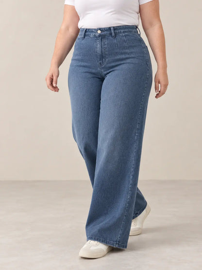 Pantalón Cashia Denim 401 denim medio, talla XL, medio plano inferior sobre modelo, con tiro alto y pernera ancha.
