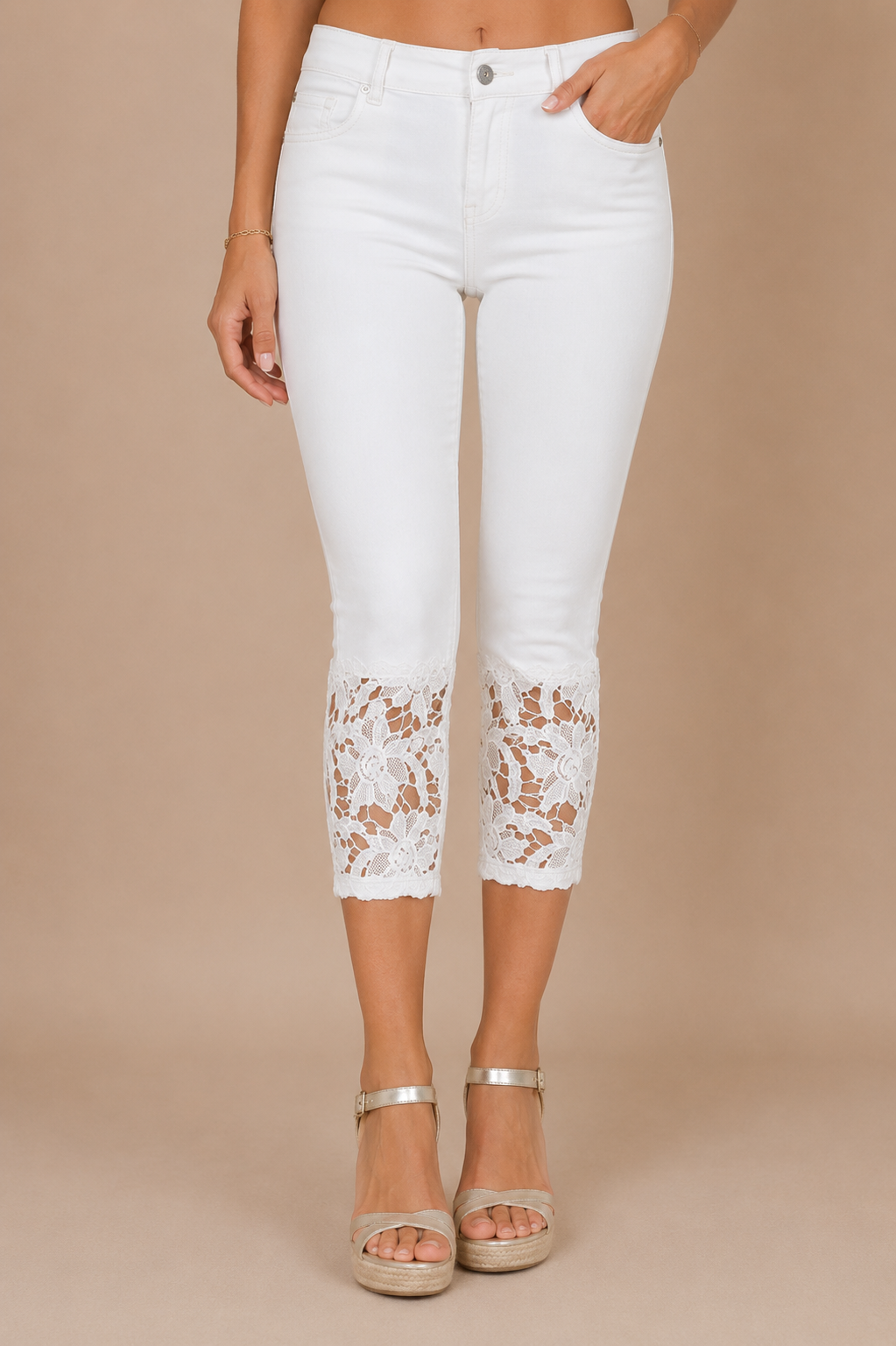 Detalle frontal del Pantalón Cashia Denim Encaje blanco de cintura alta con bajo de encaje floral blanco sobre fondo nude Cashia