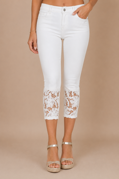 Detalle frontal del Pantalón Cashia Denim Encaje blanco de cintura alta con bajo de encaje floral blanco sobre fondo nude Cashia