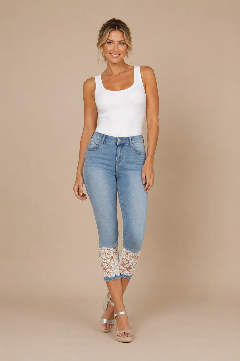 Pantalón Cashia Denim Encaje azul claro de cintura alta con detalle de encaje blanco en el bajo, combinado con camiseta blanca de tirantes anchos en fondo nude Cashia