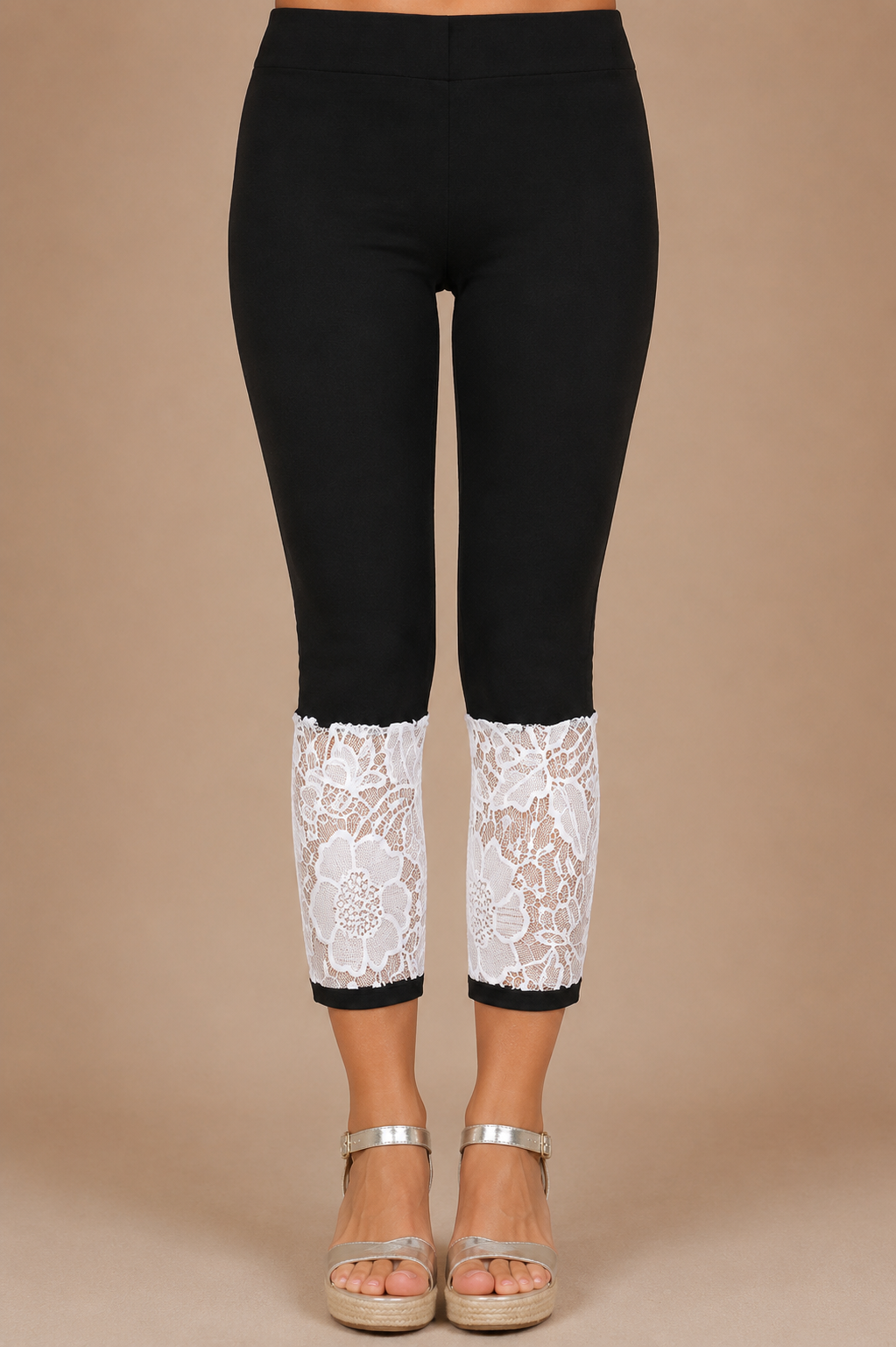 Detalle frontal del Pantalón Cashia Denim Encaje negro con panel de encaje floral blanco en el bajo sobre fondo nude Cashia