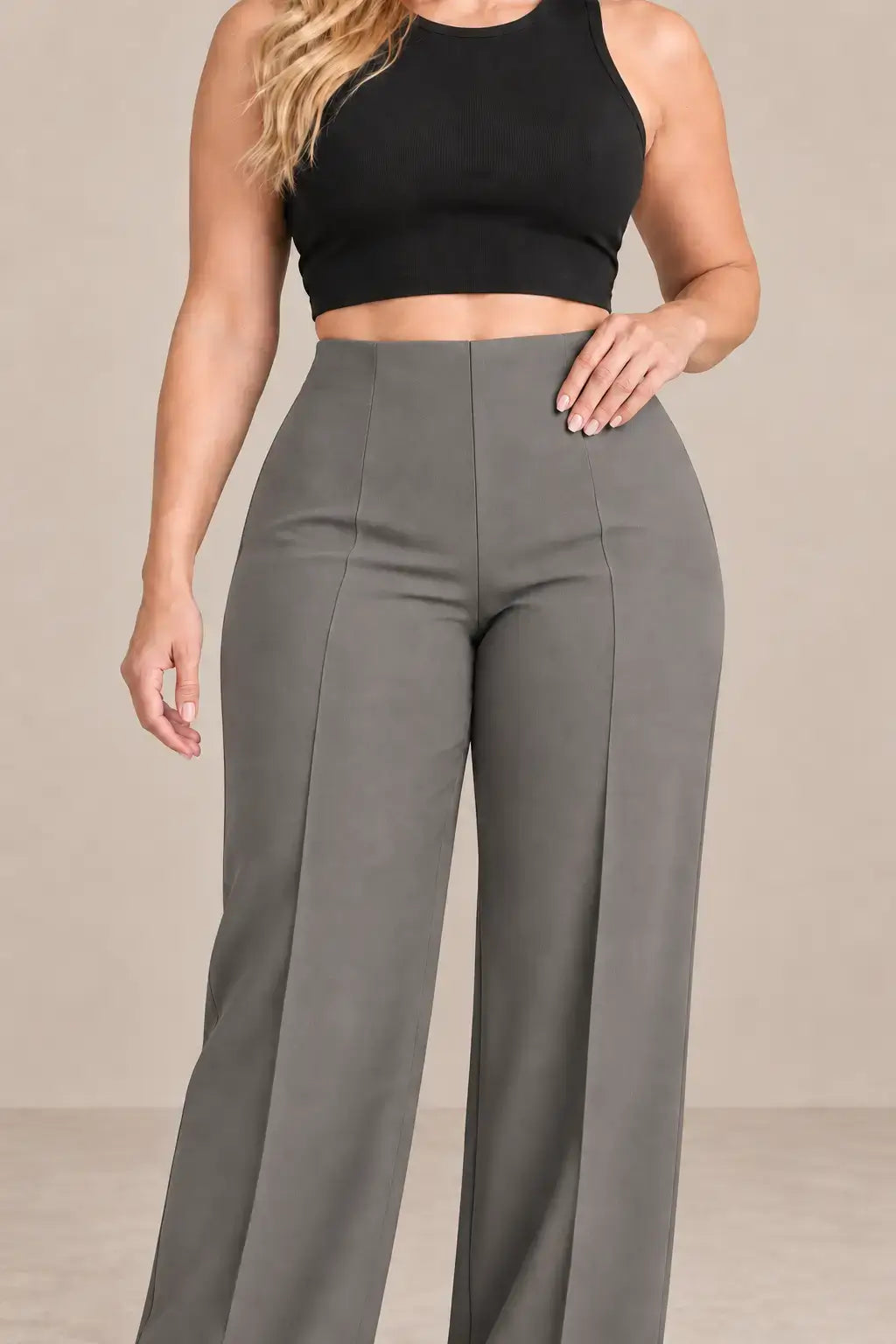 Pantalón de mujer tiro alto pierna amplia en color gris, combinado con top negro, destacando su silueta elegante.
