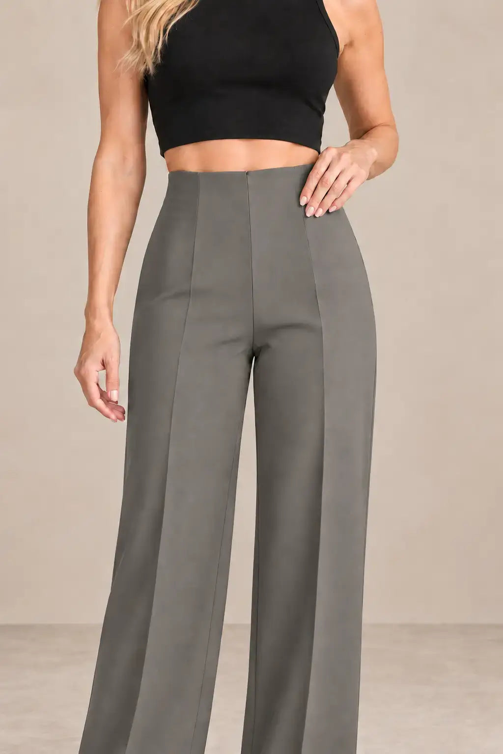 Mujer con pantalón de mujer tiro alto pierna amplia en color gris, combinado con top negro, moda elegante.