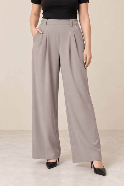 Pantalón ancho de tiro alto gris claro Cashia Vault con bolsillo, modelo de pierna ancha, usado con zapatos de tacón.