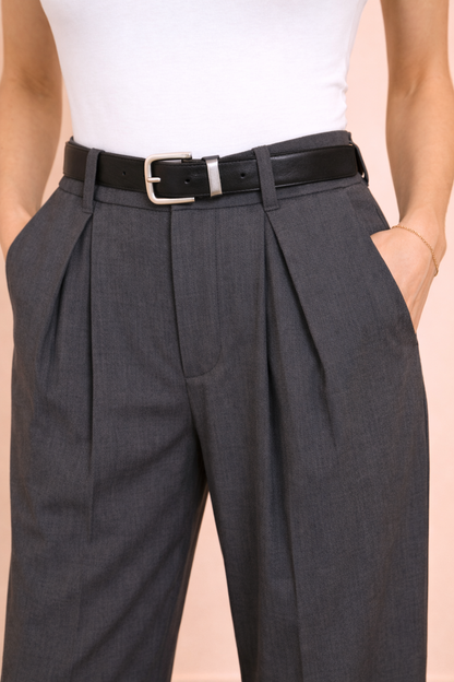 Detalle de las pinzas delanteras del Pantalón Cashia Sevilla gris de tiro alto, mostrando la estructura de la cintura y el acabado del tejido sobre fondo nude.