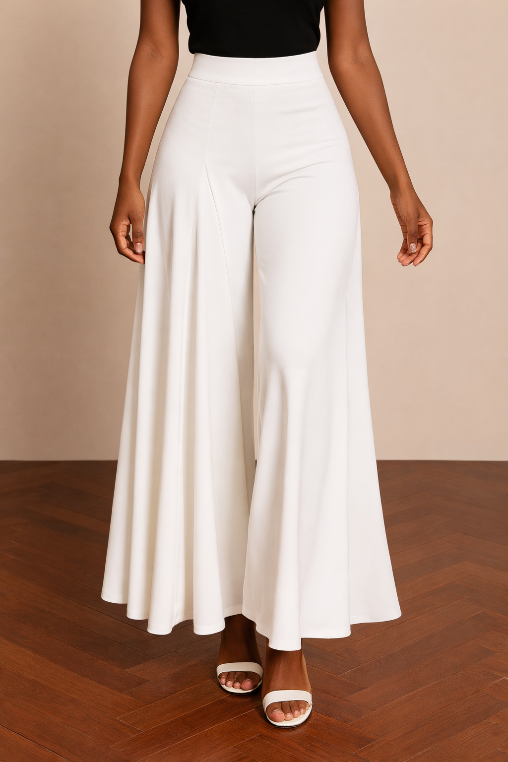 Pantalón Cashia Granada blanco en medio plano inferior, con corte amplio y caída fluida desde la cintura alta hasta el bajo, sobre fondo nude y suelo de madera en espiga.
