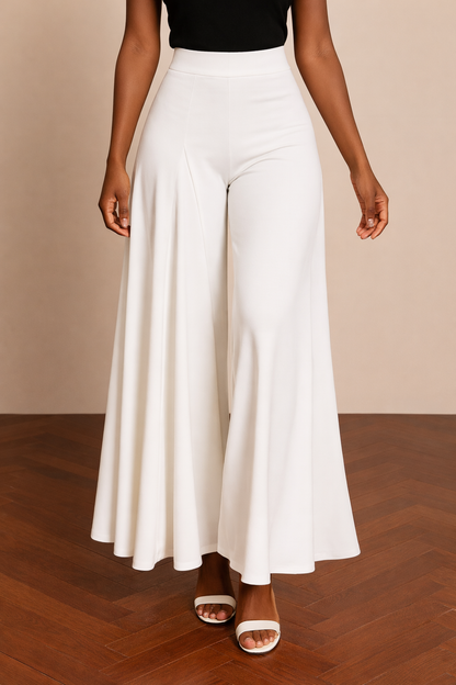 Pantalón Cashia Granada blanco en medio plano inferior, con corte amplio y caída fluida desde la cintura alta hasta el bajo, sobre fondo nude y suelo de madera en espiga.