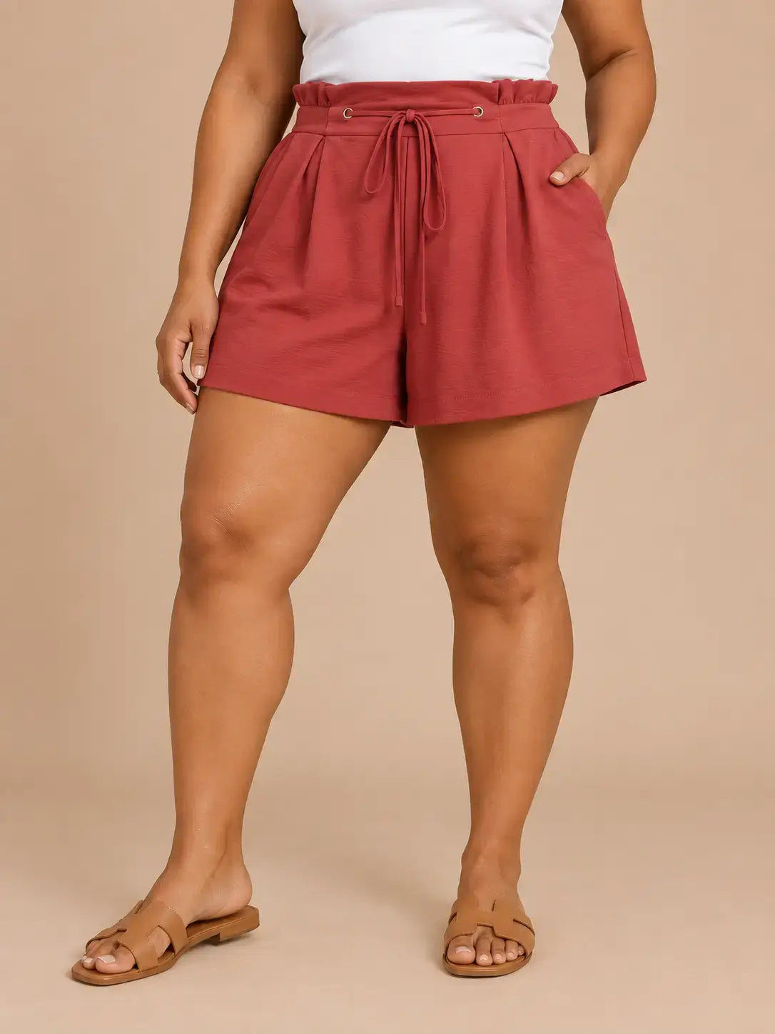 Short Cashia Arezzo color teja en talla XL, de cintura alta con lazada y corte holgado, en medio plano inferior con las piernas separadas.