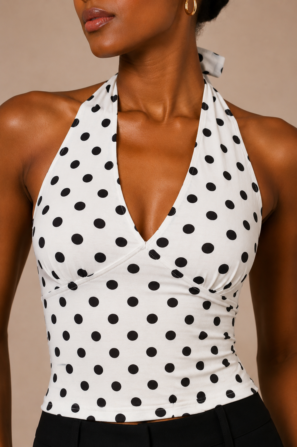 Detalle del escote en V del Top Cashia Amalfi blanco de lunares, con cuello halter anudado y acabado femenino.