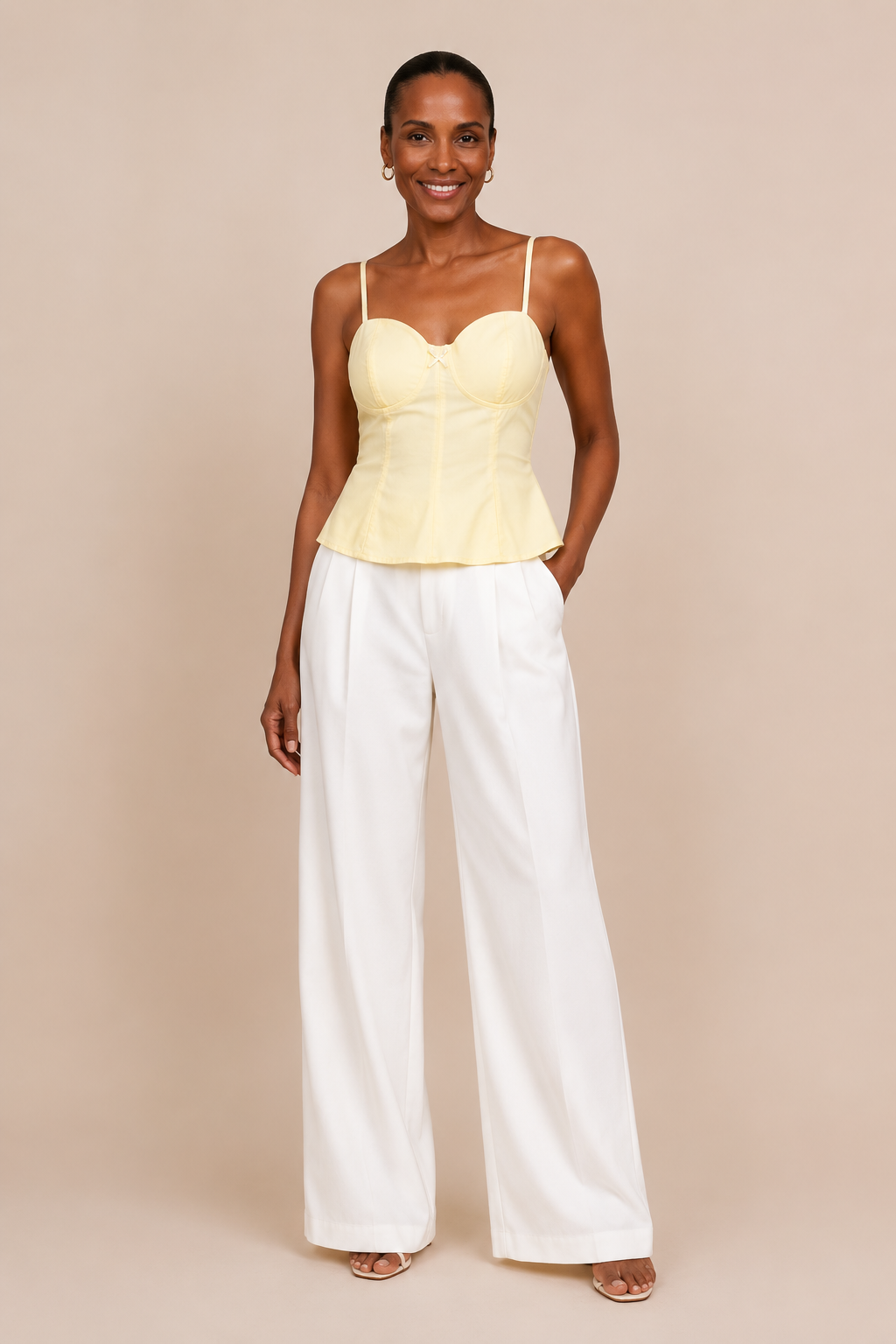 Modelo Cashia con Top Cashia Bari amarillo y pantalón blanco wide leg, vista frontal de cuerpo entero sobre fondo nude.
