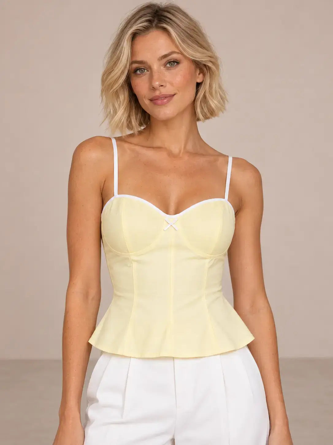 Modelo Cashia talla XS con Top Cashia Bari amarillo y pantalón blanco en medio plano superior.