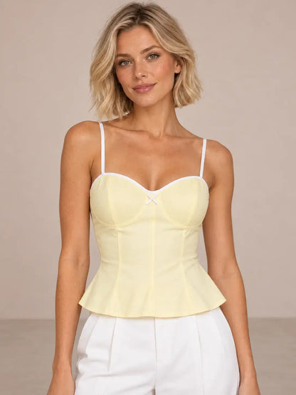 Modelo Cashia talla XS con Top Cashia Bari amarillo y pantalón blanco en medio plano superior.