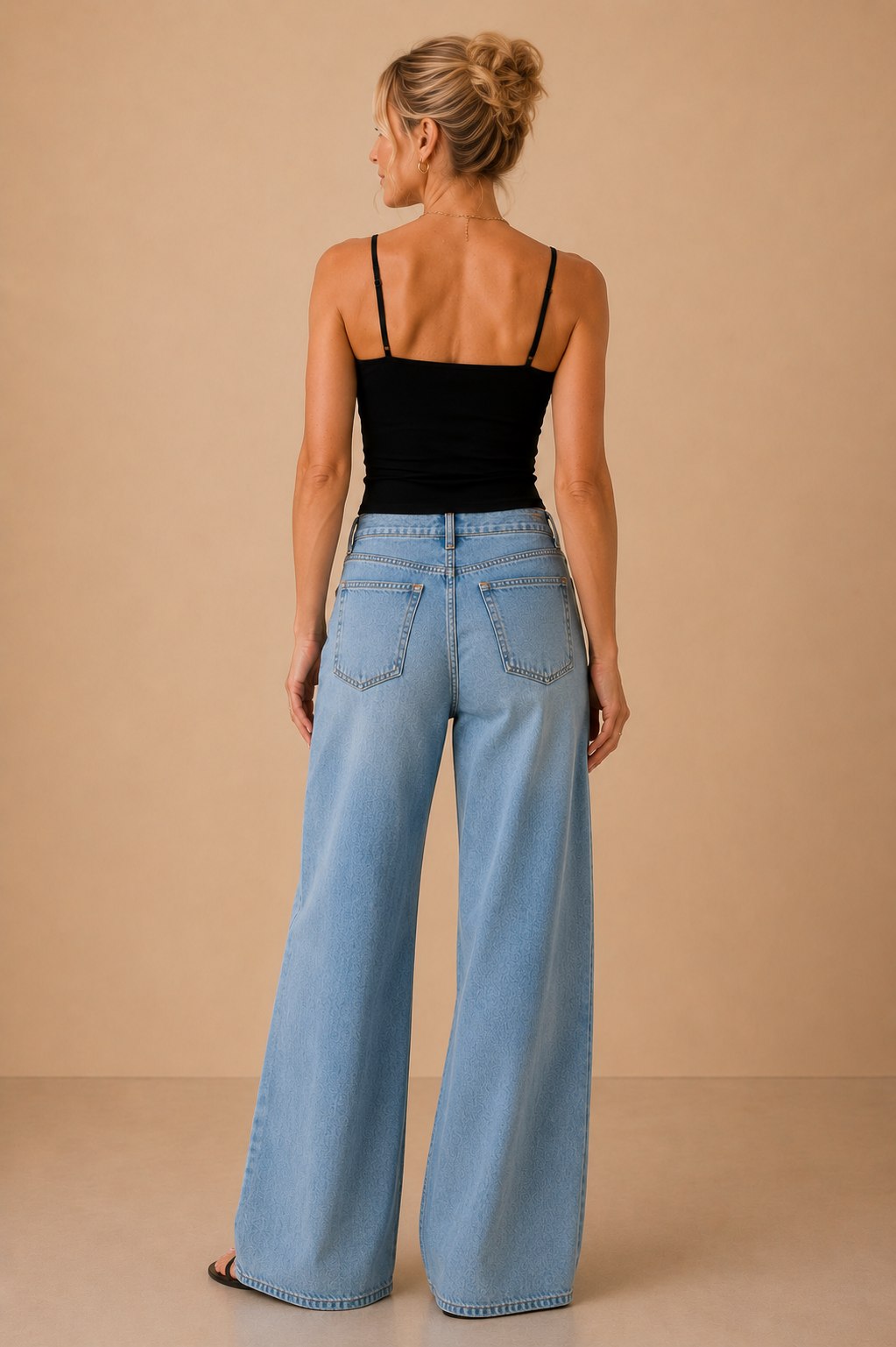 Top Cashia Basic Tirantes negro visto de espalda, con tirantes finos y corte ajustado, combinado con pantalón tejano wide leg.