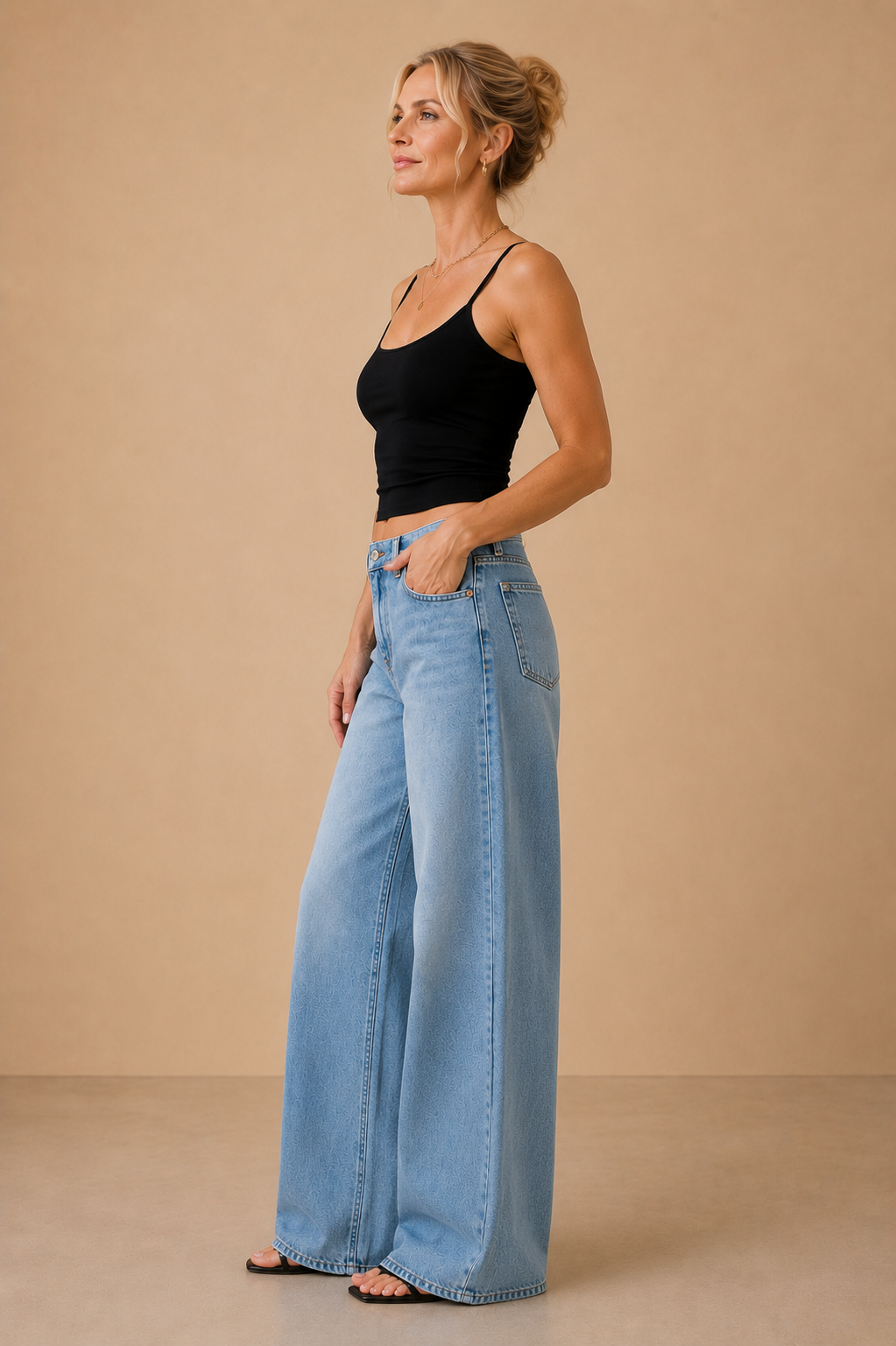 Top Cashia Basic Tirantes negro visto de perfil, con ajuste slim fit y combinado con pantalón tejano wide leg.