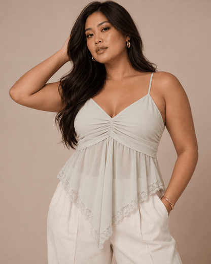 Top Cashia Lucca gris claro en talla L, con escote en V, tejido semitransparente y bajo asimétrico rematado con encaje.