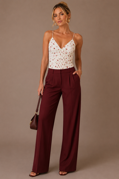 Modelo rubia elegante con Top Cashia Portofino floral blanco y pantalón burdeos wide leg en plano frontal.