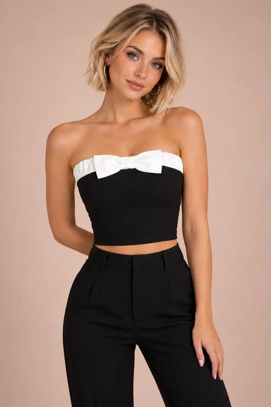 Top Cashia Valencia negro con lazo blanco en modelo talla XS, medio plano superior