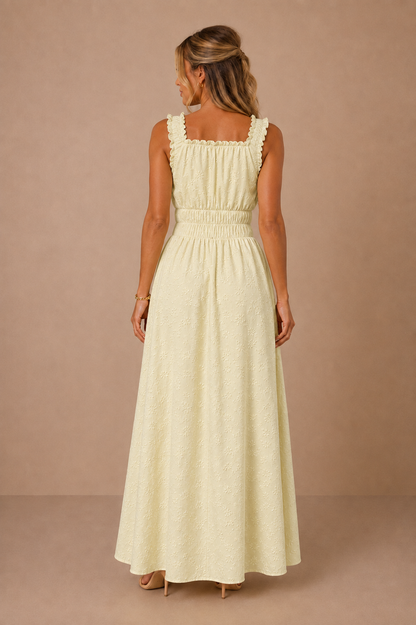 Vestido Cashia amarillo limón con brocado floral, escote cuadrado trasero y cintura elástica, vista de espalda.