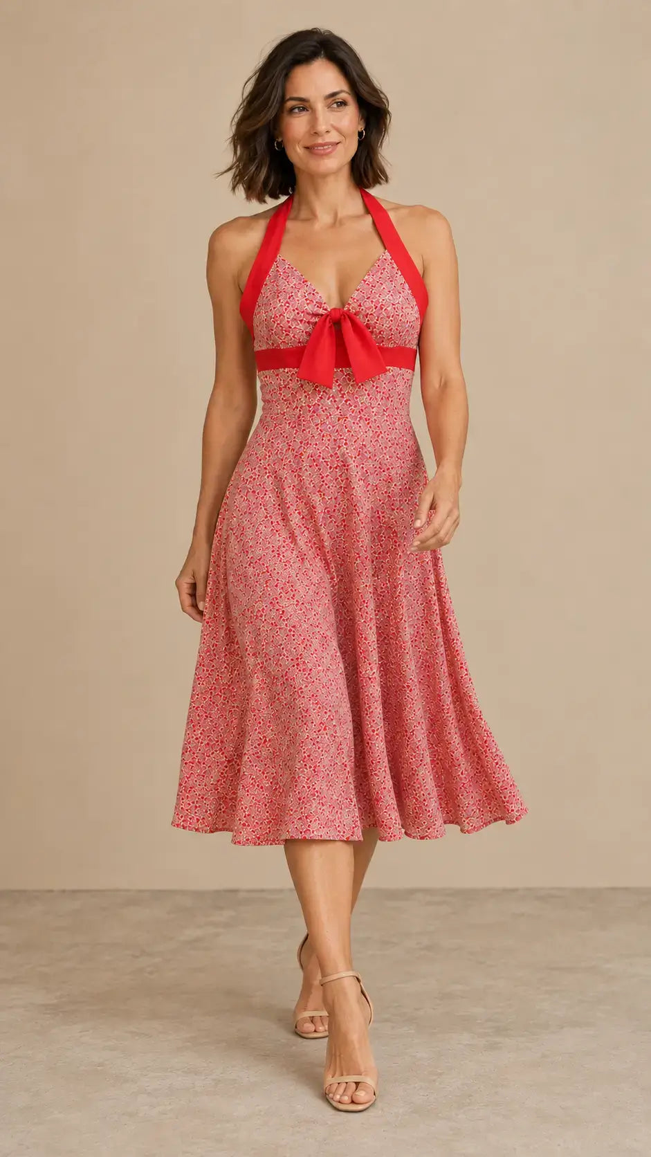 Modelo Cashia talla M con corte bob suelto y vestido Cashia Cádiz rojo floral, en pose dinámica sobre fondo nude.