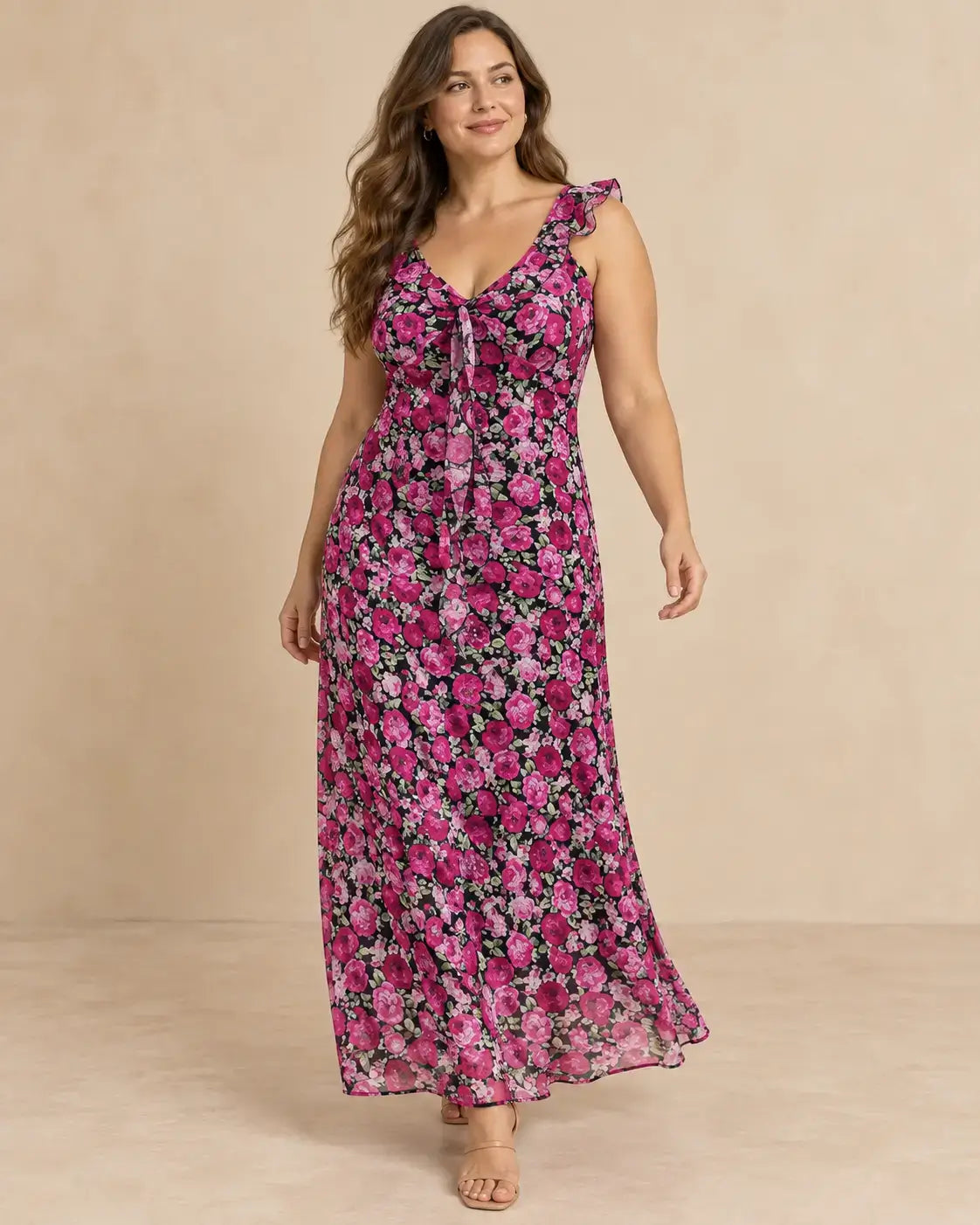 Modelo Cashia talla L con vestido largo negro estampado de flores rosas y fucsias, escote en V y silueta fluida sin vuelo.