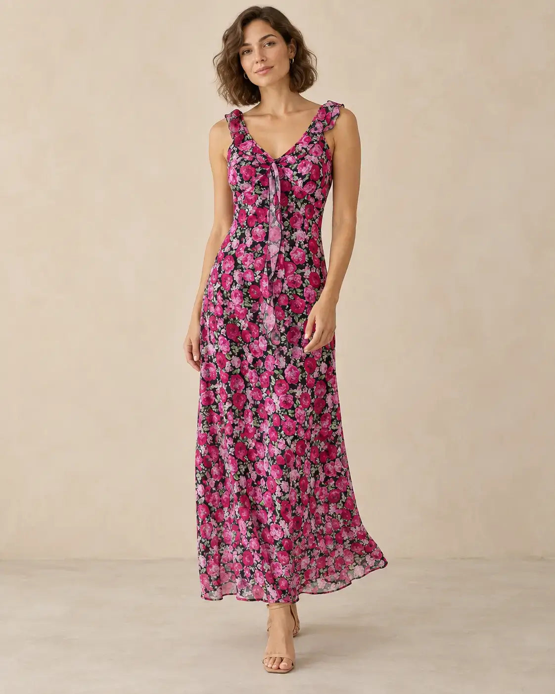 Modelo Cashia talla M con vestido largo negro de flores fucsias, tirantes con volantes y falda de caída natural.