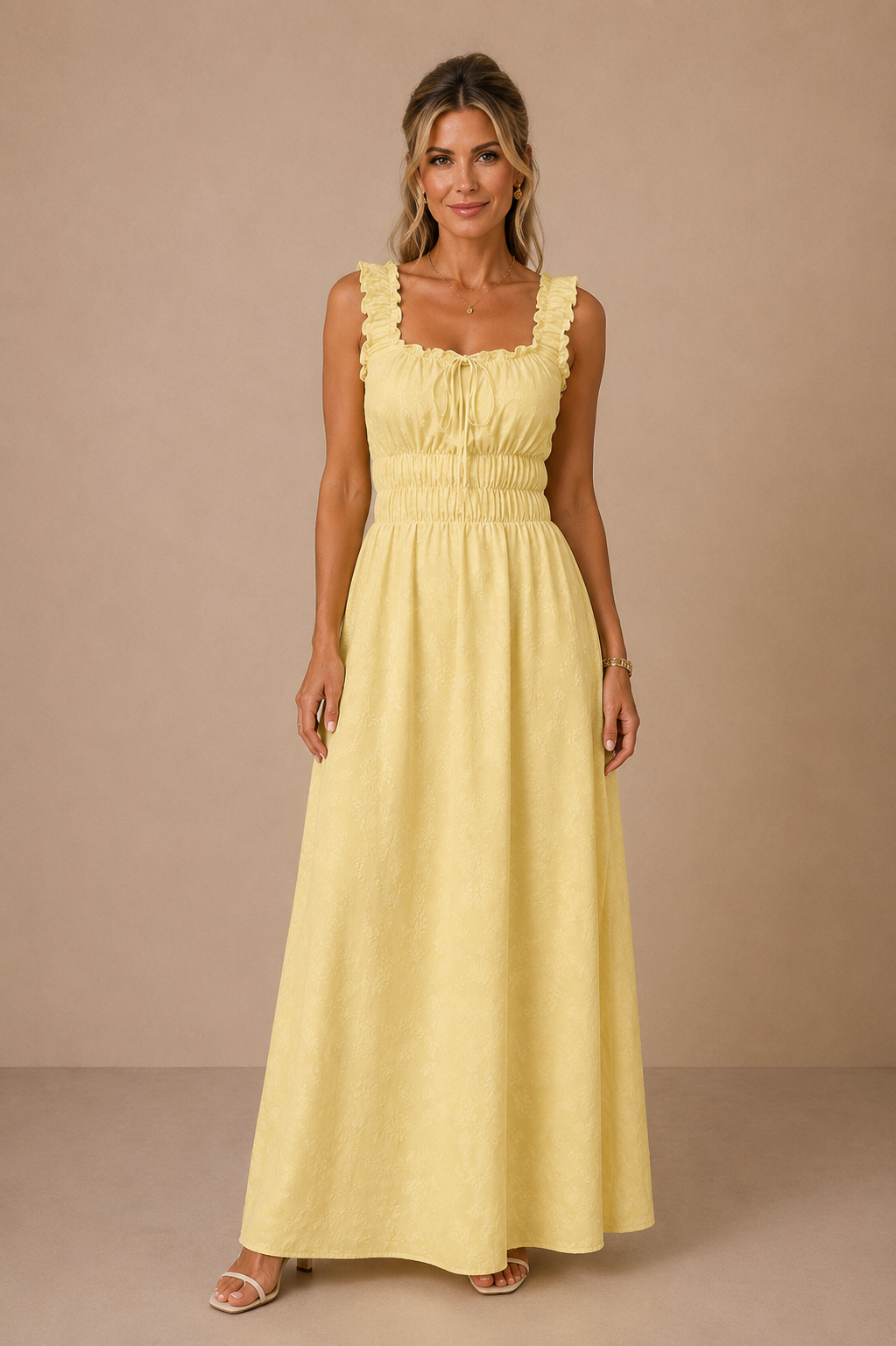 Modelo Cashia rubia de 40 años, elegante y maquillada, con pelo semirecogido. Lleva el Vestido Cashia Palermo amarillo. Vista frontal de cuerpo entero sobre fondo nude con suelo definido.