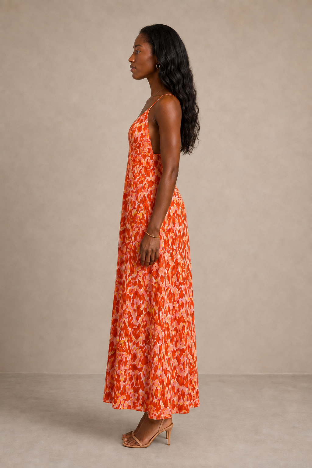 Vestido Cashia Salerno largo y estampado, visto de perfil sobre fondo nude.