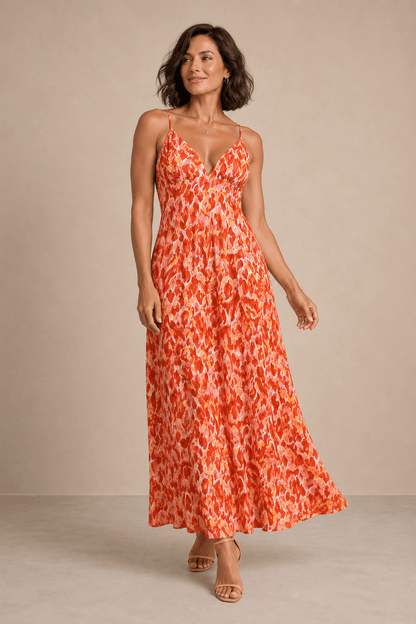 Vestido Cashia Salerno naranja estampado en modelo talla M de pelo corto, con escote en V, tirantes finos y falda larga fluida.